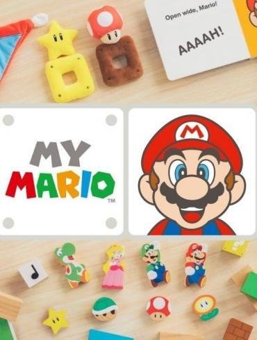 Un'immagine colorata che mostra i vari prodotti della serie My Mario: un set di blocchi di legno, il libro "Hello, Mario!" e l'interfaccia dell'app.