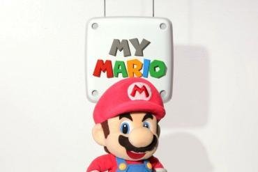 Una rappresentazione colorata e allegra di Mario Peluche in stile stop motion, con il logo di MyMario il simbolo per indicare il lancio dei video.