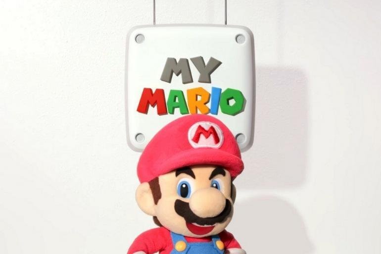 Una rappresentazione colorata e allegra di Mario Peluche in stile stop motion, con il logo di MyMario il simbolo per indicare il lancio dei video.