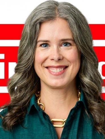 Ritratto di Devon Pritchard, la donna che diventerà Presidente di Nintendo of America, con il logo di Nintendo sullo sfondo.