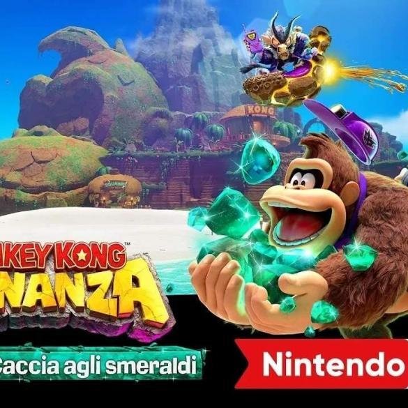 Primo piano dinamico di Donkey Kong accovacciato e circondato da smeraldi verdi luminosi, con una giovane esploratrice che salta alla sua destra. Sullo sfondo, un'isola tropicale lussureggiante e King K. Rool su un veicolo volante. Il logo "Donkey Kong Bananza" è in basso a sinistra, sotto una banda rossa con scritto "Isola DK + Caccia agli smeraldi". In alto a sinistra è presente il logo "Nintendo Switch 2", e in basso a destra la dicitura "Nintendo Direct".