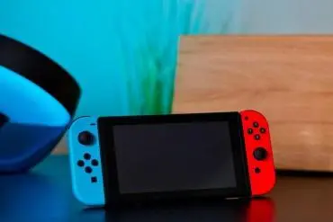 Nintendo Switch su tavolo con schermo nero e tagliere