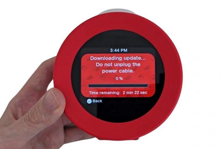 Un primo piano dell'Orologio sonoro Nintendo Alarmo con il display che mostra le istruzioni per il download di un nuovo aggiornamento di sistema.