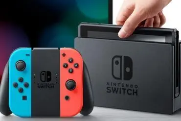 Primo piano della Nintendo Switch con il dock dove una mano vuole rimuoverla dal dock
