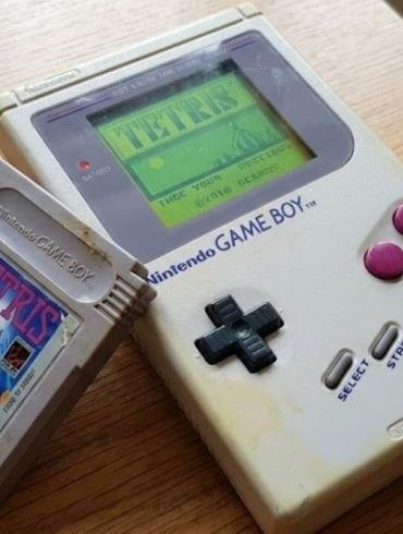 Game Boy originale DMG-01 grigio con cassetta di Tetris appoggiata sopra