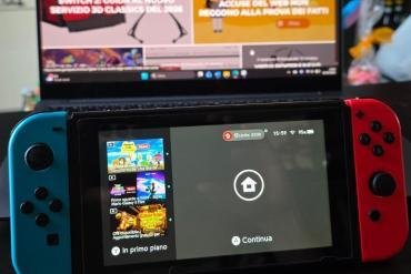 Confronto tra Nintendo Switch OLED e Nintendo Switch 2 su una scrivania con guida all'acquisto 2026