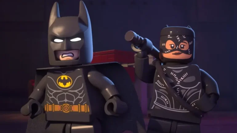 Minifigure LEGO di Batman e Catwoman in una scena notturna di LEGO Batman: L'Eredità del Cavaliere Oscuro.