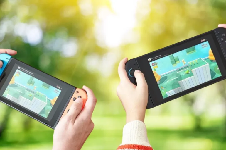 Due giocatori che usano il multiplayer locale e la funzione GameShare all'aperto su due console Nintendo Switch 2 separate.